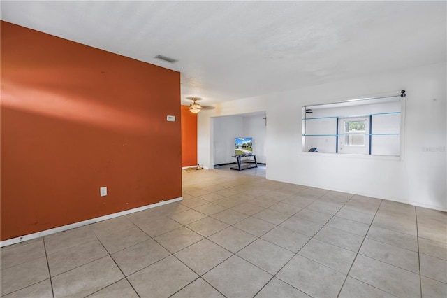 tiled spare room featuring ceiling fan