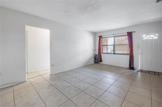 tiled spare room with a textured ceiling