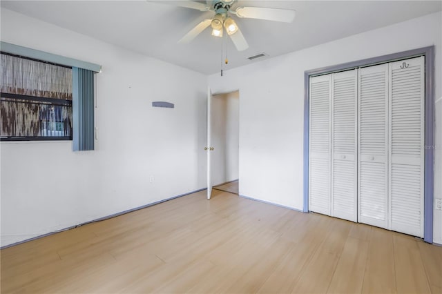 unfurnished bedroom with ceiling fan, wood-type flooring, and a closet