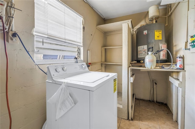 laundry area featuring electric water heater, light tile patterned floors, and independent washer and dryer