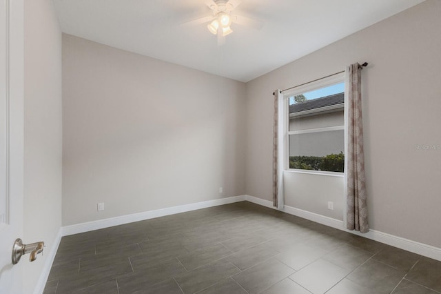 empty room with ceiling fan and baseboards