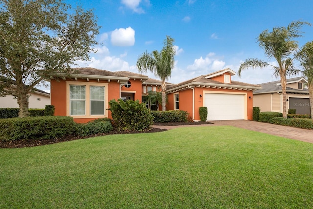 view of front of property with a garage, decorative driveway, a front lawn, and stucco siding