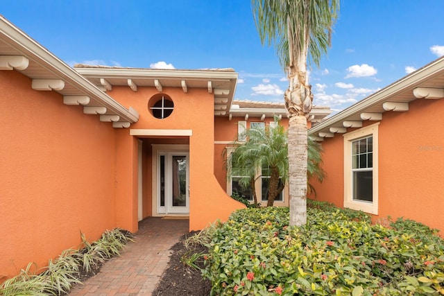 doorway to property featuring stucco siding