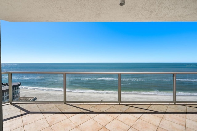 balcony with a water view and a beach view