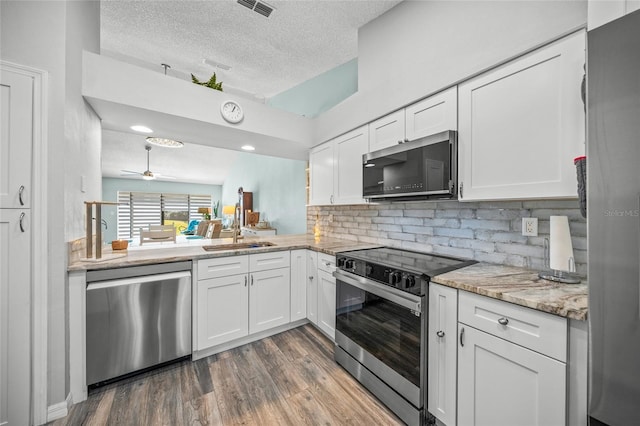 kitchen featuring dark hardwood / wood-style floors, sink, white cabinets, decorative backsplash, and stainless steel appliances