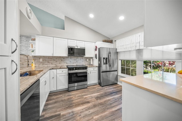 kitchen with dark hardwood / wood-style floors, white cabinetry, lofted ceiling, sink, and stainless steel appliances