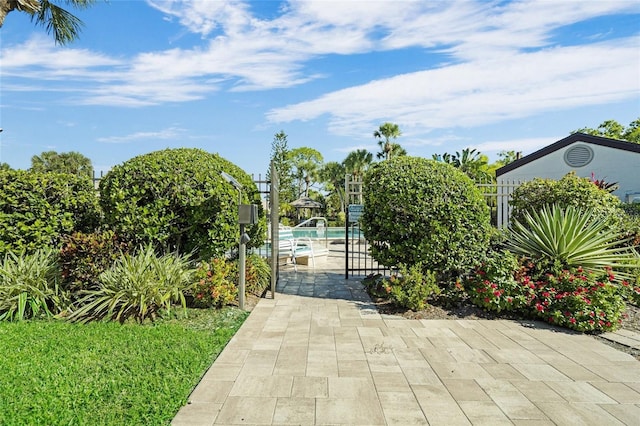 view of gate with a fenced in pool and a patio