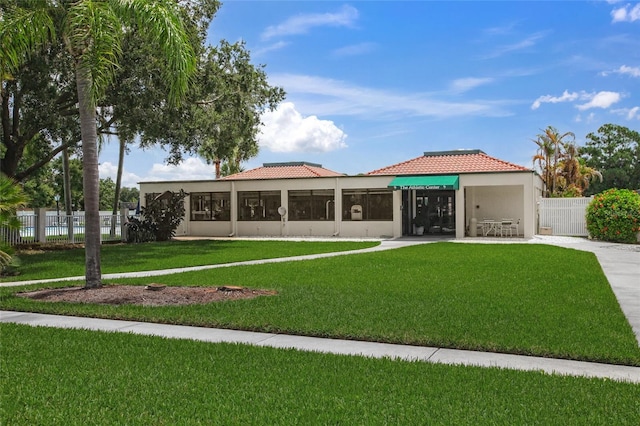 view of front of property featuring a front lawn and a sunroom