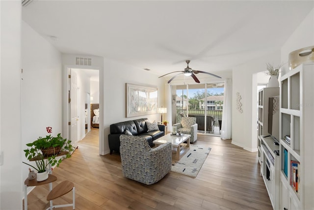 living room with light wood-type flooring and ceiling fan