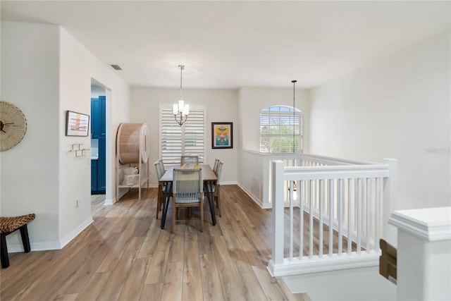 dining space with an inviting chandelier and light hardwood / wood-style floors