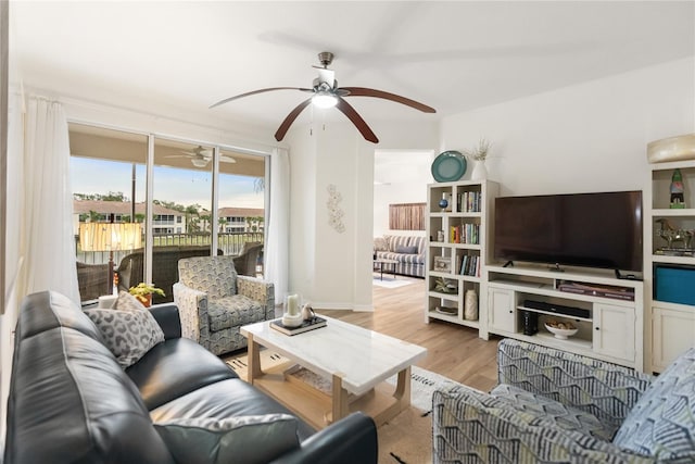 living room with light hardwood / wood-style flooring and ceiling fan