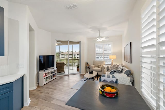 living room featuring ceiling fan and light hardwood / wood-style floors