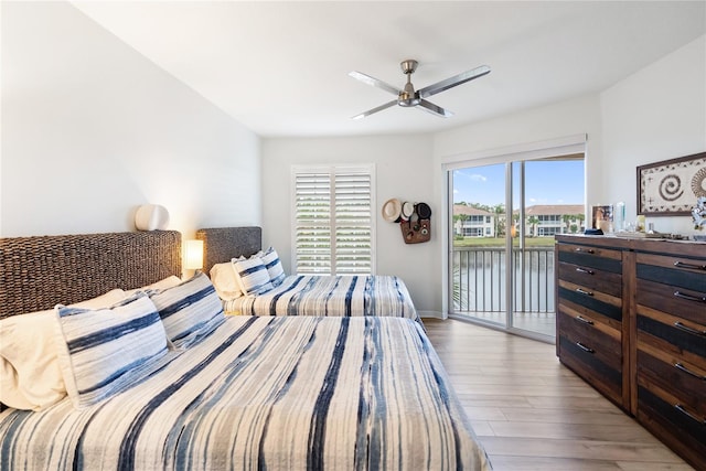 bedroom with light hardwood / wood-style flooring, a water view, ceiling fan, and access to outside