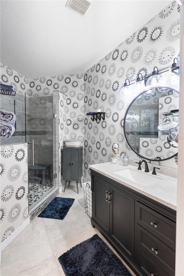 bathroom featuring a shower with door, vanity, and tile patterned flooring