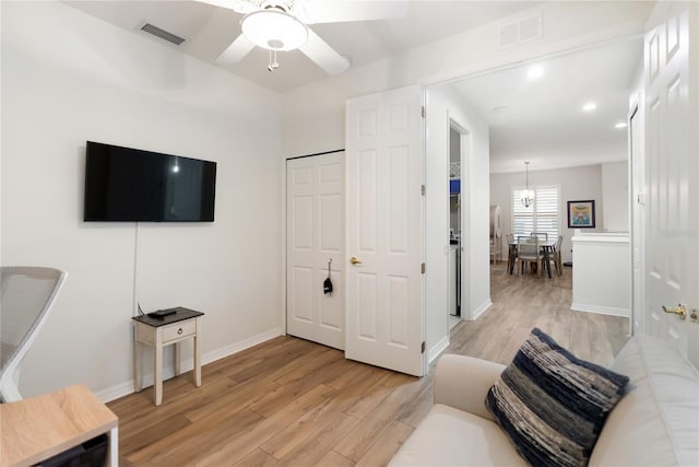 living room featuring ceiling fan and light hardwood / wood-style flooring