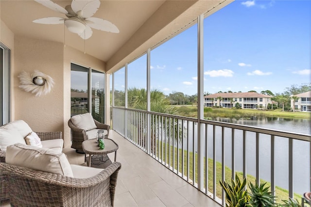 sunroom featuring ceiling fan, a wealth of natural light, and a water view