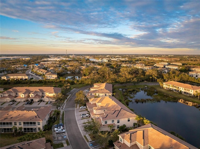 aerial view at dusk featuring a water view