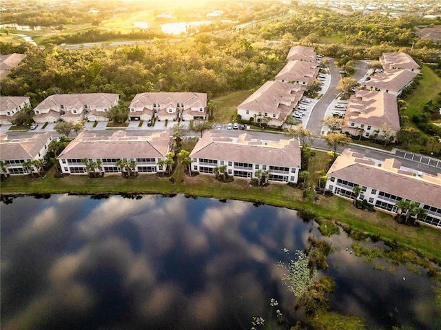 aerial view at dusk featuring a water view