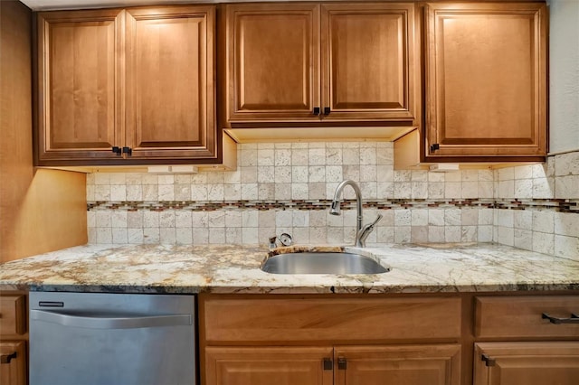 kitchen featuring light stone countertops, sink, dishwasher, and tasteful backsplash