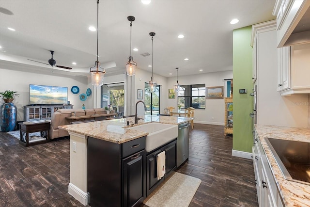 kitchen featuring sink, white cabinetry, an island with sink, decorative light fixtures, and stainless steel dishwasher