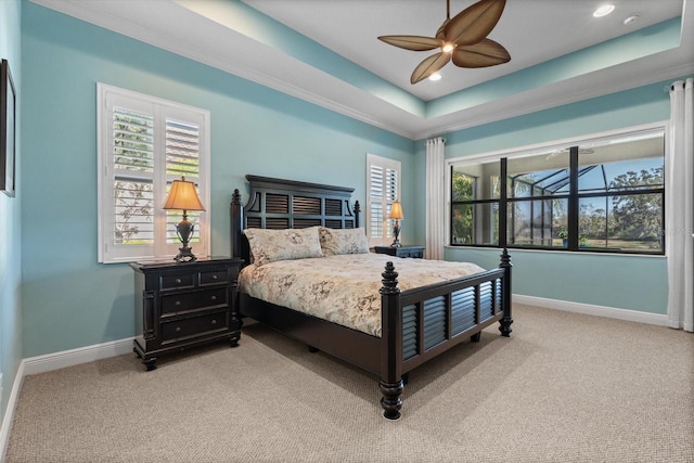 bedroom with light carpet, a tray ceiling, ornamental molding, and ceiling fan