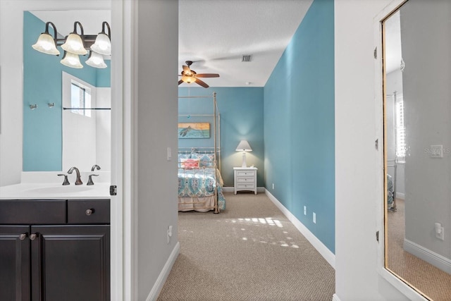 bedroom with sink, a textured ceiling, carpet floors, and ceiling fan