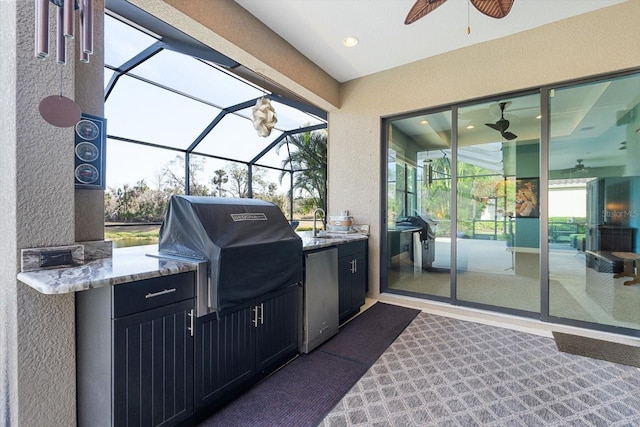 view of patio / terrace with grilling area, exterior kitchen, ceiling fan, and glass enclosure