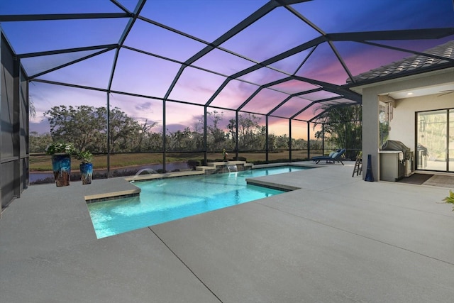 pool at dusk featuring a lanai, pool water feature, and a patio area