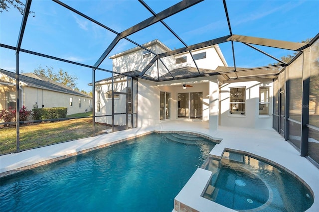 view of pool with ceiling fan, glass enclosure, an in ground hot tub, and a patio