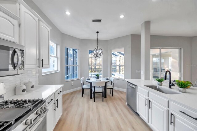 14146 Cattle Egret Pl, Bradenton, FL 34202 - kitchen featuring white cabinetry, appliances with stainless steel finishes, a notable chandelier, decorative light fixtures, and sink