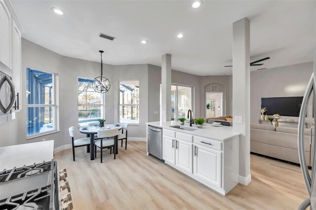 14146 Cattle Egret Pl, Bradenton, FL 34202 - kitchen featuring appliances with stainless steel finishes, decorative light fixtures, ceiling fan with notable chandelier, white cabinets, and sink