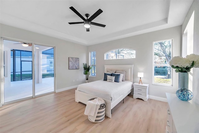 14146 Cattle Egret Pl, Bradenton, FL 34202 - bedroom with ceiling fan, a raised ceiling, light hardwood / wood-style flooring, and access to outside
