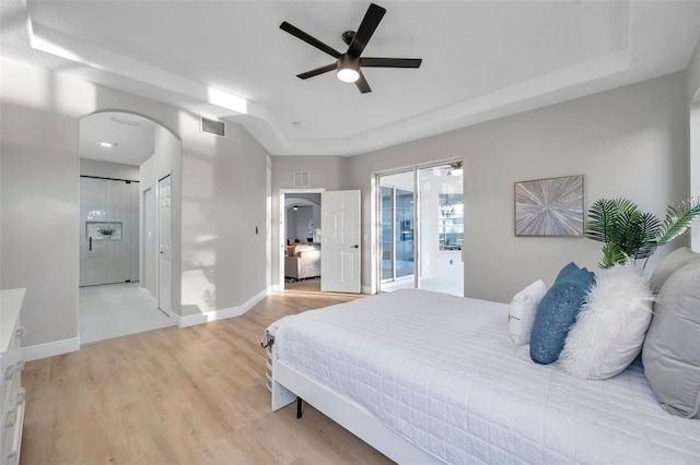 14146 Cattle Egret Pl, Bradenton, FL 34202 - bedroom featuring ceiling fan, light wood-type flooring, access to exterior, and a tray ceiling