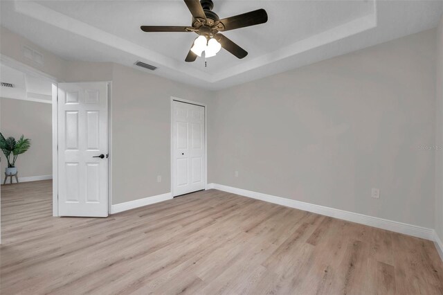 14146 Cattle Egret Pl, Bradenton, FL 34202 - unfurnished bedroom with a raised ceiling, ceiling fan, light wood-type flooring, and a closet