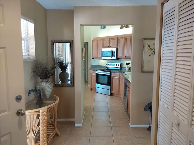 kitchen with appliances with stainless steel finishes and light tile patterned flooring