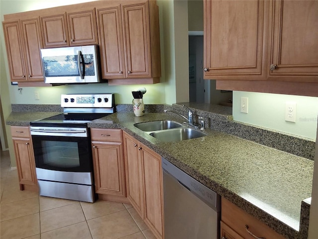 kitchen featuring light tile patterned floors, appliances with stainless steel finishes, and sink