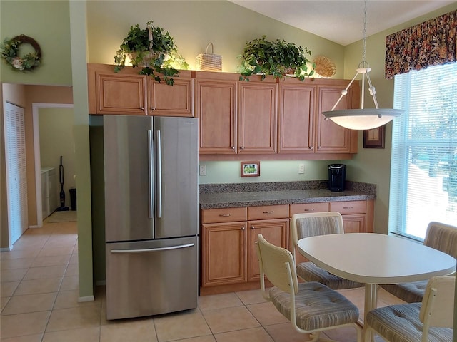 kitchen featuring light tile patterned floors, hanging light fixtures, and stainless steel fridge