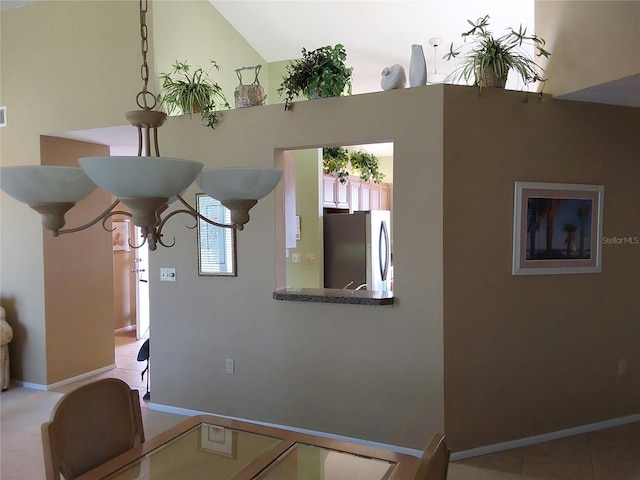 interior space with lofted ceiling, a chandelier, and light tile patterned flooring