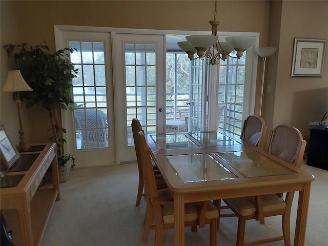 carpeted dining room featuring a chandelier