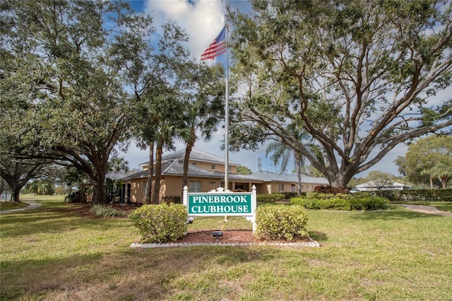 community / neighborhood sign featuring a yard