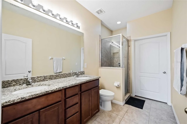 bathroom with a shower with shower door, toilet, vanity, and tile patterned flooring