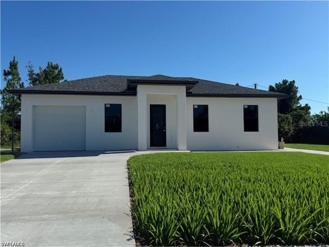 view of front of property featuring a garage and a front yard