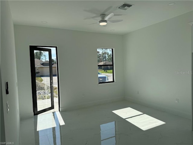 spare room featuring ceiling fan and plenty of natural light