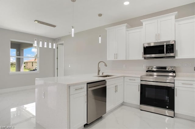 kitchen featuring sink, stainless steel appliances, white cabinetry, and pendant lighting