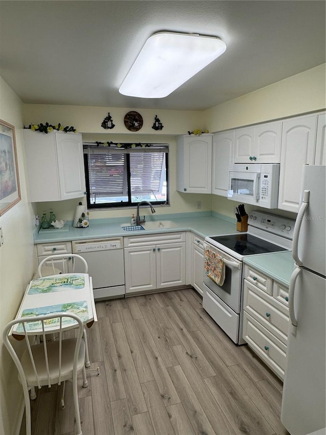 kitchen featuring white cabinets, light wood-type flooring, sink, and white appliances