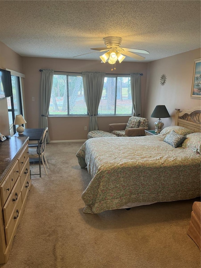 carpeted bedroom featuring a textured ceiling, ceiling fan, and multiple windows