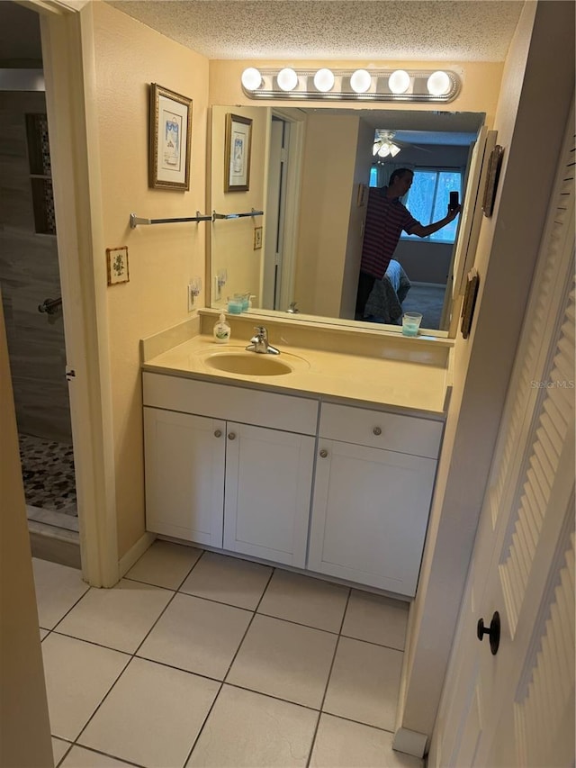 bathroom with vanity, a shower, tile patterned floors, and a textured ceiling