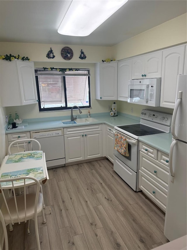 kitchen with sink, light hardwood / wood-style flooring, white cabinets, and white appliances