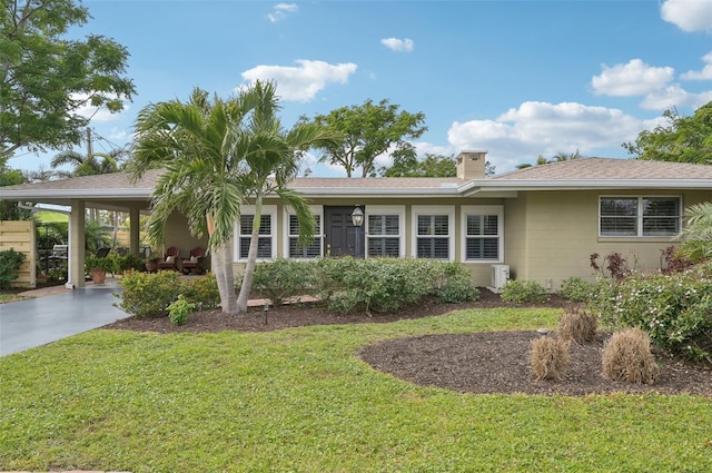 single story home with a front yard and a carport