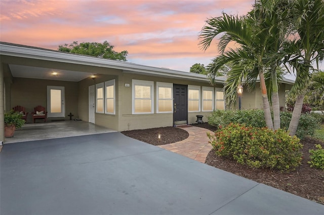 exterior entry at dusk with a carport